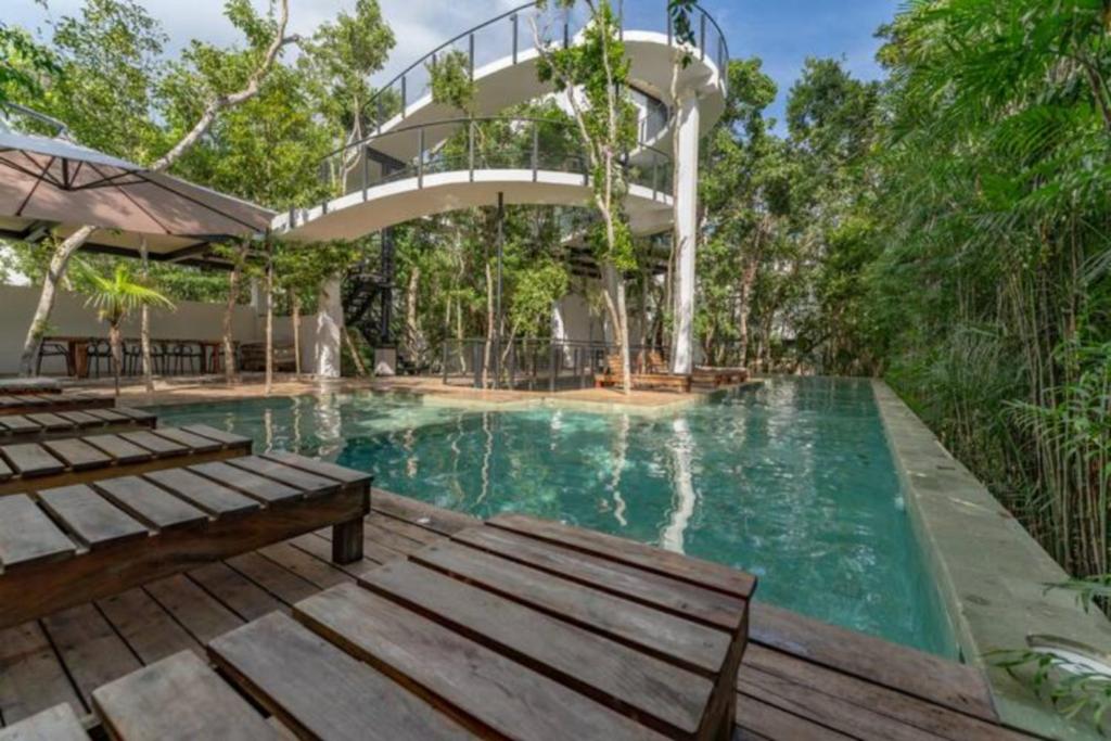 ein Schwimmbad mit einer Rutsche in der Mitte in der Unterkunft Exclusive Villa "Town House" Luxury Amenities in Tulum in Tulum
