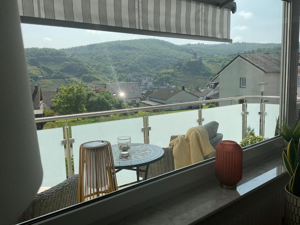 a balcony with a table and chairs and a view of the water at Tarrazza Ferienwohnungen Erpeldinger in Ellenz-Poltersdorf