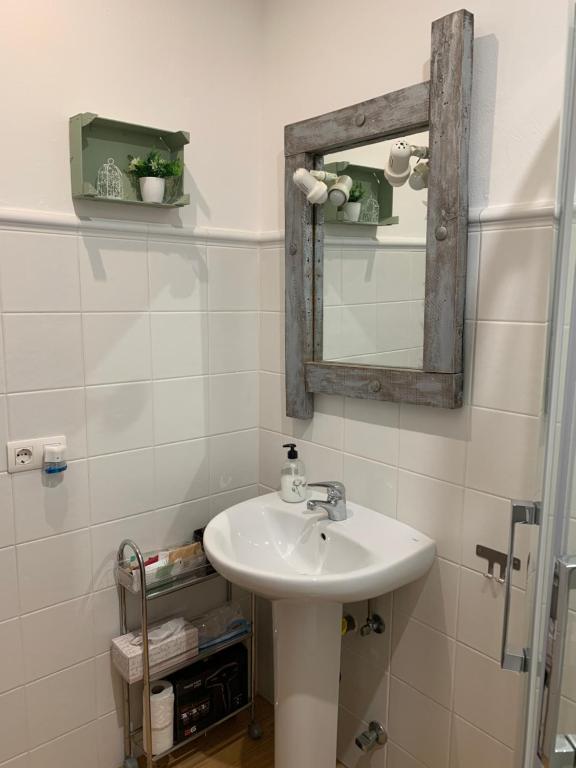 uma casa de banho com um lavatório e um espelho em Buhardilla Rústica Mirando a Santa Catalina em Jerez de los Caballeros
