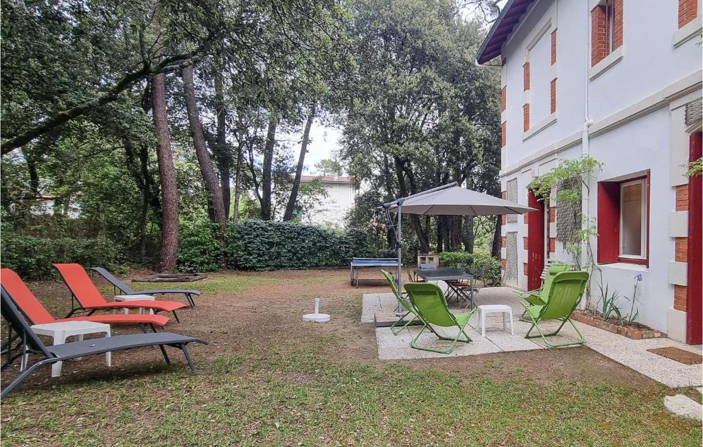 a group of chairs and an umbrella next to a building at Stunning Home In Saint-palais-sur-mer With Wifi And 6 Bedrooms in Saint-Palais-sur-Mer