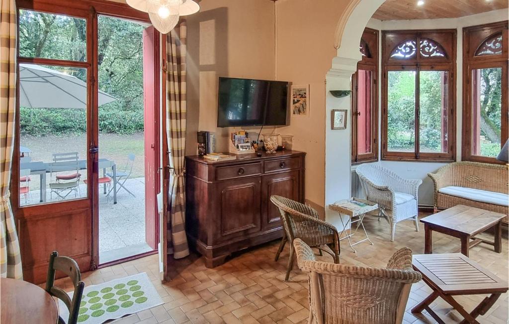 a living room with a television and a table and chairs at Stunning Home In Saint-palais-sur-mer With Wifi And 6 Bedrooms in Saint-Palais-sur-Mer