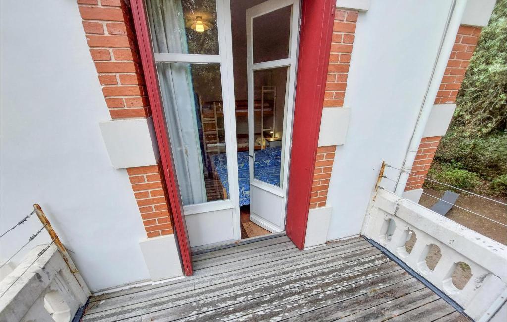a red door on a building with a wooden stairs at Stunning Home In Saint-palais-sur-mer With Wifi And 6 Bedrooms in Saint-Palais-sur-Mer