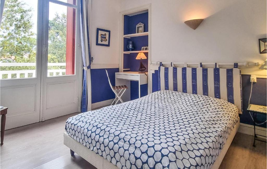 a bedroom with a blue and white bed and a window at Stunning Home In Saint-palais-sur-mer With Wifi And 6 Bedrooms in Saint-Palais-sur-Mer