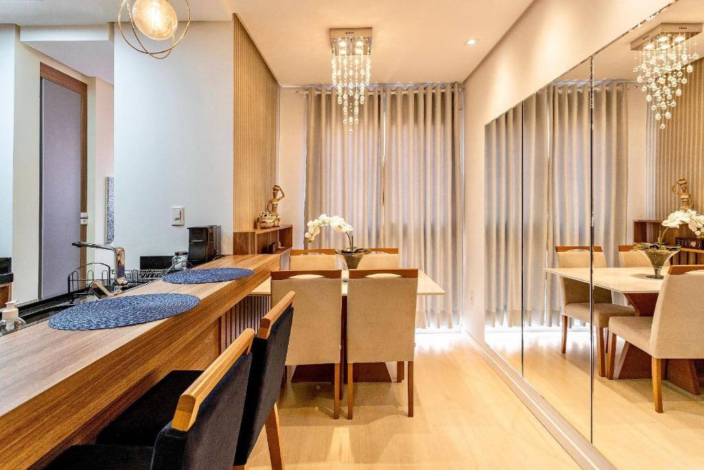 a dining room with a long table and chairs at Apartamento Villaggio Del Veneto 1 dorm by Achei in Canela
