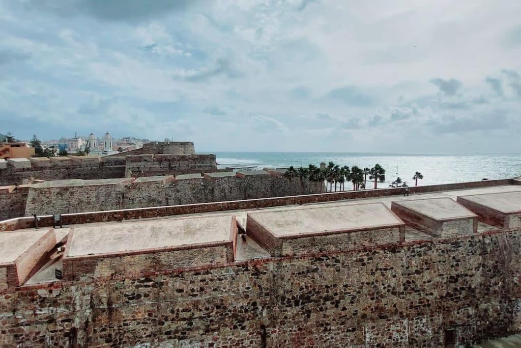 eine alte Backsteinmauer mit dem Ozean im Hintergrund in der Unterkunft Acogedor piso cerca de la playa in Ceuta