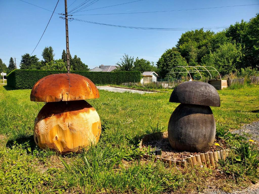 two large wooden mushrooms sitting in the grass at Le Gauliat in Espartignac