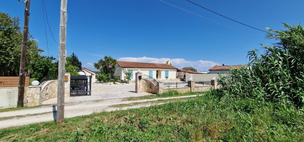 una strada con recinzione e case sullo sfondo di villa κούκος ad Áyios Dhimítrios