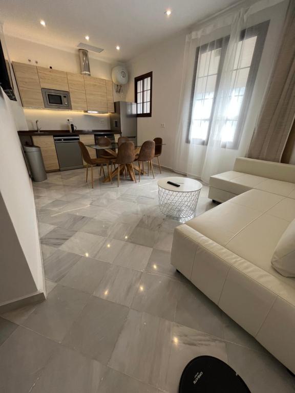 uma sala de estar com um sofá branco e uma cozinha em MonKeys Apartments Santa Clara Deluxe em Sevilha