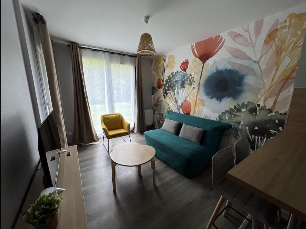 ein Wohnzimmer mit einem blauen Sofa und einem Tisch in der Unterkunft L’entrelacs in Équemauville