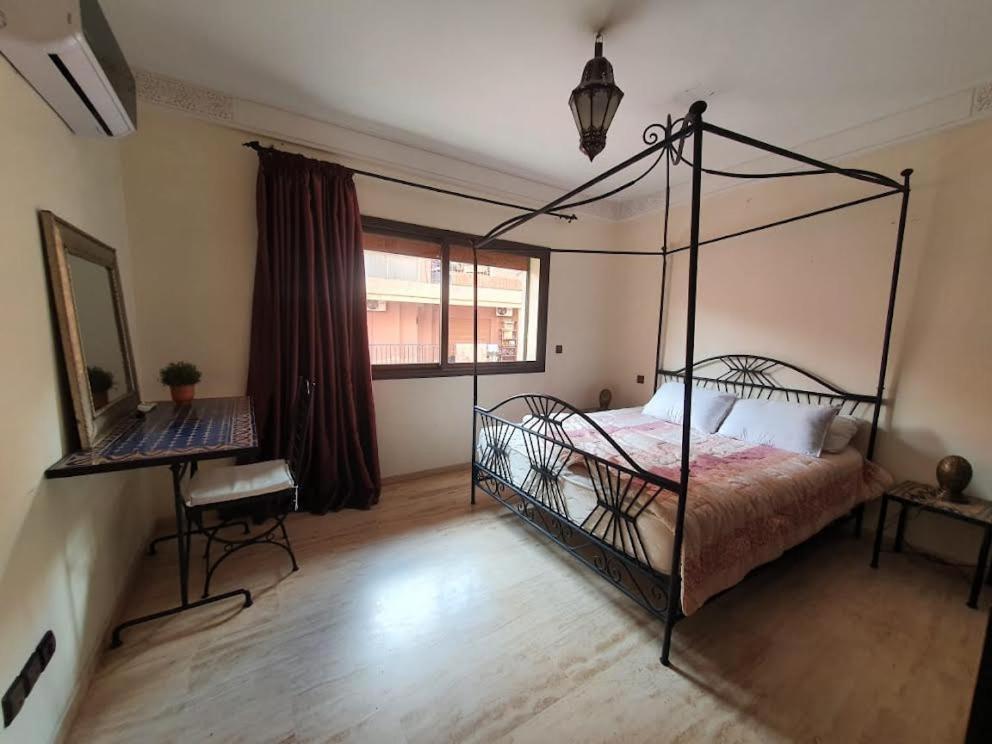 a bedroom with a metal canopy bed and a window at Jacaranda in Marrakesh