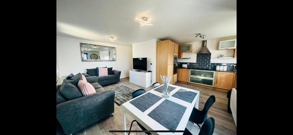 a living room with a couch and a table at 2bed luxury modern apartment in Swansea