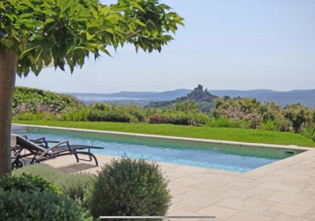 une piscine avec deux chaises et une table dans l'établissement Villa Maelvi, à Grimaud