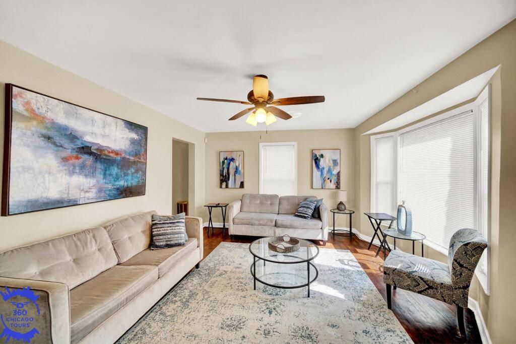 a living room with a couch and a ceiling fan at The Katerina Residence in Calumet City