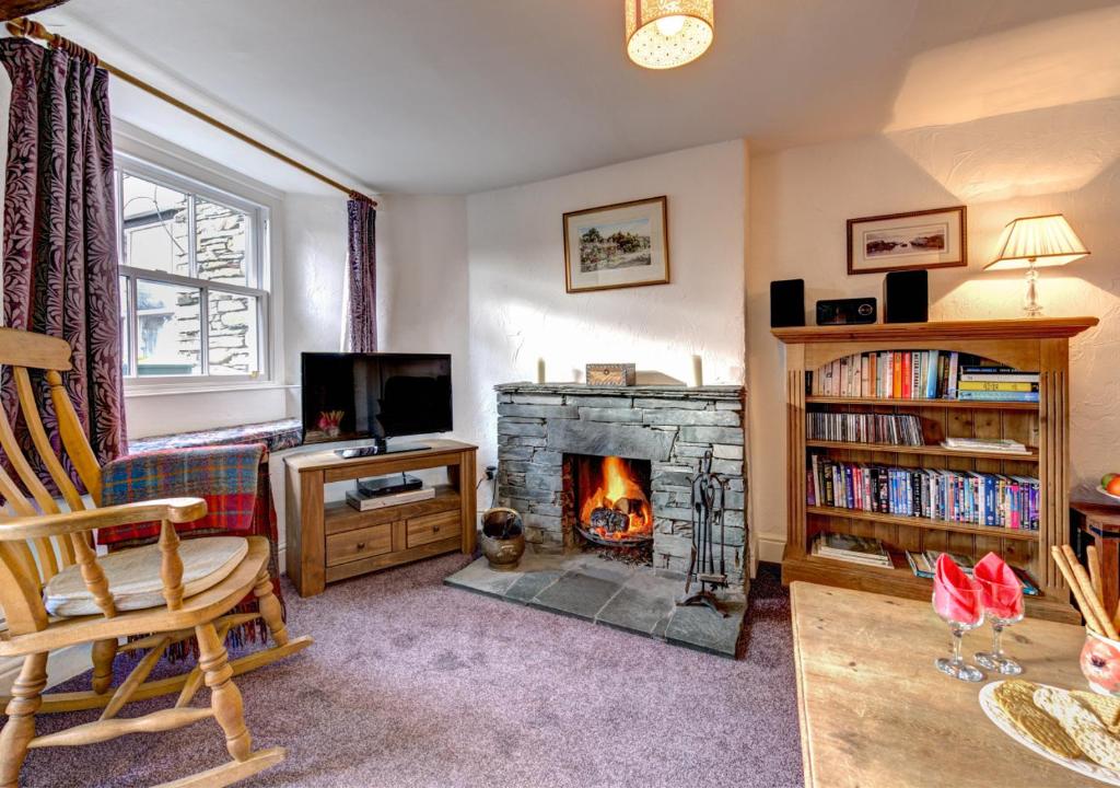 a living room with a fireplace and a couch at Rose Cottage in Chapel Stile