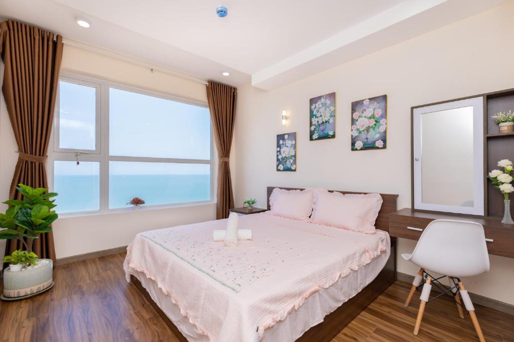 a bedroom with a bed and a large window at Căn hộ OASKY 2 phòng ngủ view biển ngay quảng trường Vũng Tàu in Vung Tau