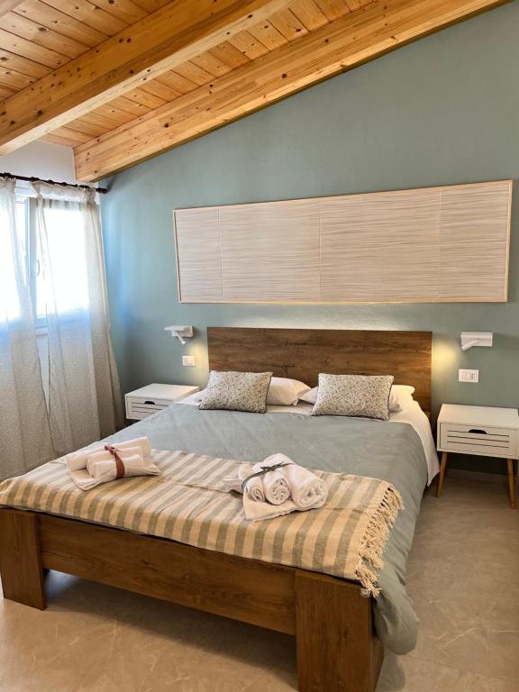 a bedroom with a large bed with two towels on it at B&b AlgueRoof in Alghero