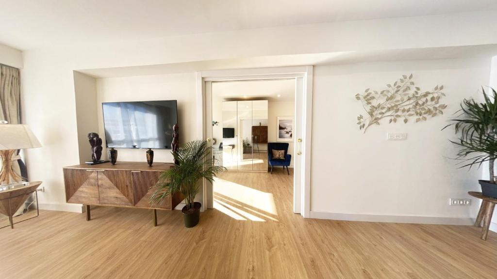 a living room with a table and a tv at Miramar Luxurious flat, 3 double rooms, free parking, terrace, completely new in San Sebastián