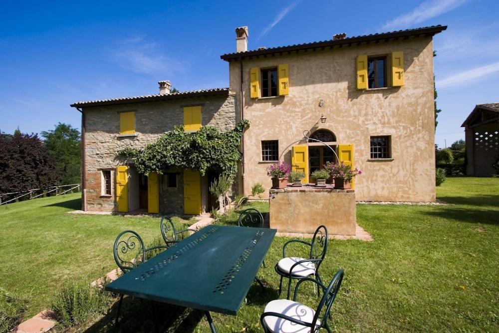 uma casa com uma mesa de piquenique verde em frente em Villa dell'Ovo em Brisighella