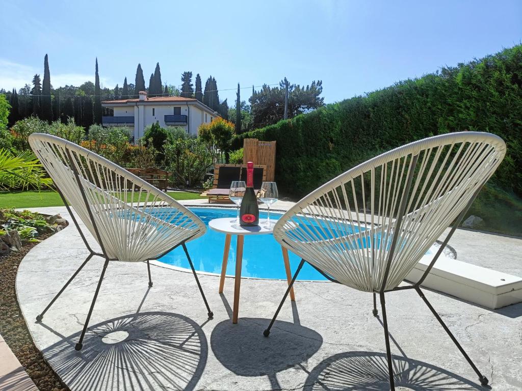 dos sillas y una mesa frente a una piscina en Picnic Room and Pool, en Castelnuovo del Garda