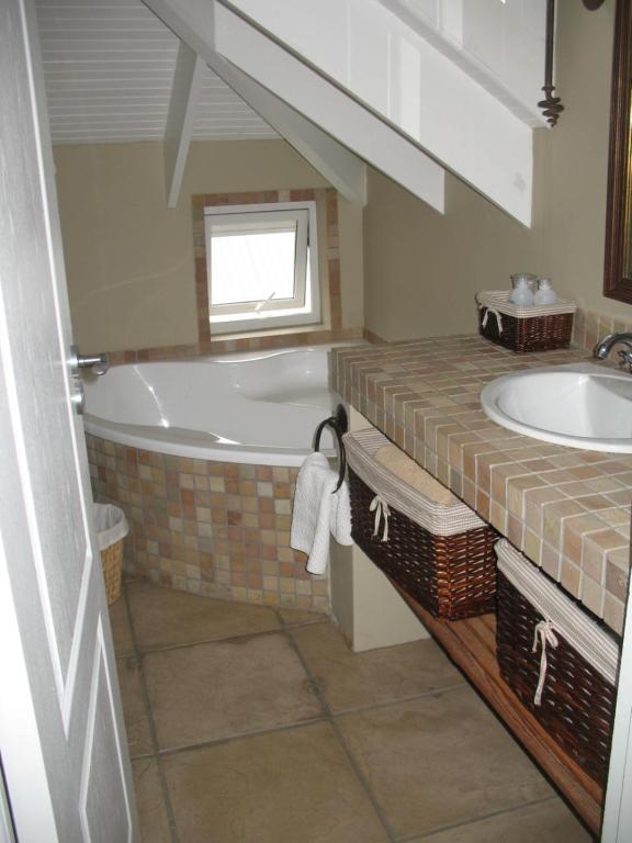 y baño con bañera y lavamanos. en Knysna River View Apartment, en Knysna