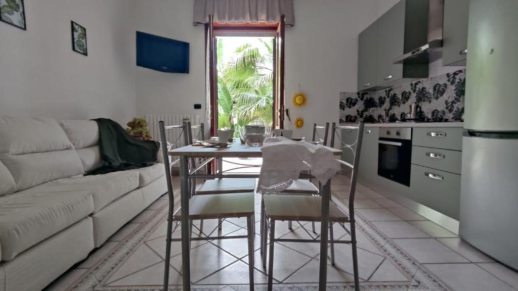 a kitchen and living room with a table and chairs at Maison Lido Silvana in Pulsano