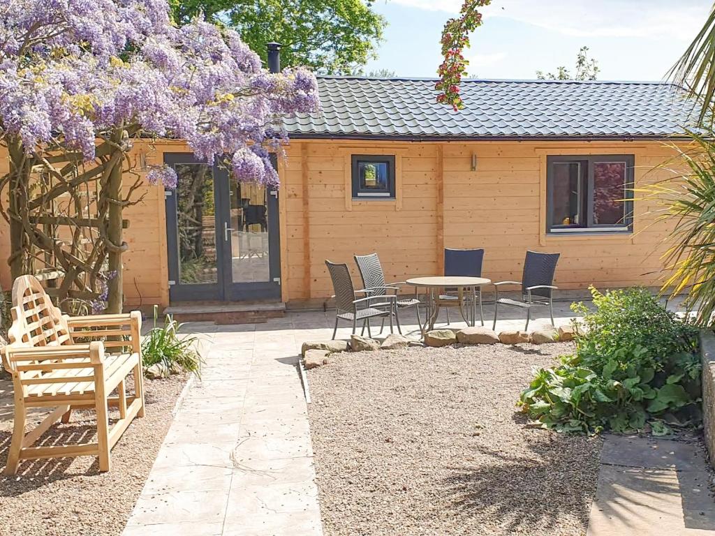 a patio with chairs and a table and purple flowers at West End Lodge in Barmston