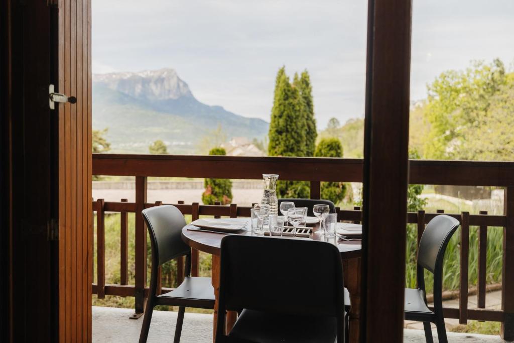 a table on a balcony with a view of a mountain at Bel appartement 6 couchages au plan d&#39;eau d&#39;Embrun in Embrun