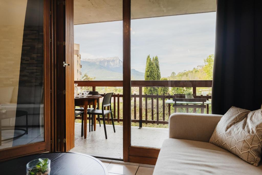 a living room with a view of the mountains from a balcony at Bel appartement 6 couchages au plan d&#39;eau d&#39;Embrun in Embrun