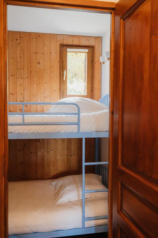 two bunk beds in a room with a window at Bel appartement 6 couchages au plan d&#39;eau d&#39;Embrun in Embrun