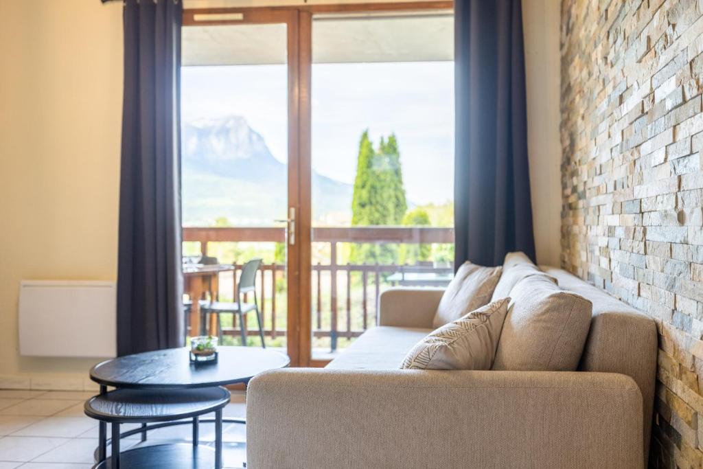 a living room with a couch and a balcony at Bel appartement 6 couchages au plan d&#39;eau d&#39;Embrun in Embrun