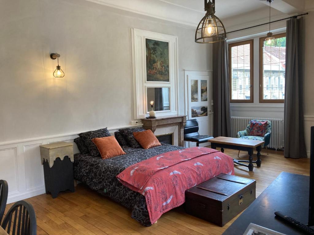 a bedroom with a bed and a living room at Maison La Tourelle in Baume-les-Dames