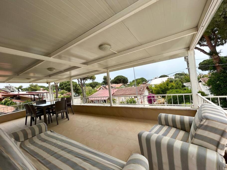 a screened in porch with a table and chairs at Somos Flats - Mavişehir in Didim