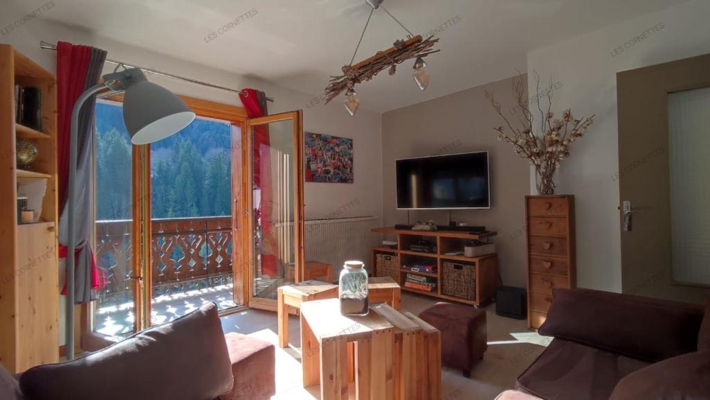 a living room with a couch and a tv at Appartement meublé classé 3 étoiles de 72 m2, 2 chambres in Morzine