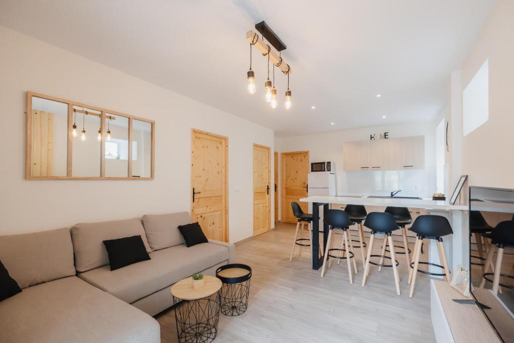 a living room and kitchen with a couch and a table at Charmant T3 en Centre Ville #1 in Embrun