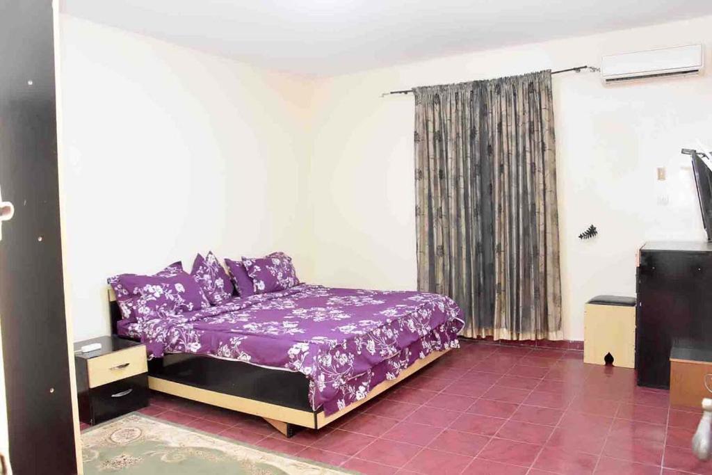 a bedroom with a purple bed and a window at Jolie Maison in Nouakchott