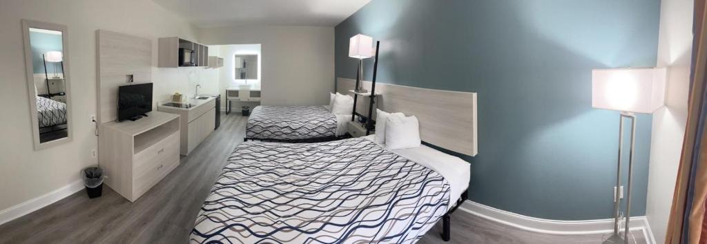 ein Hotelzimmer mit 2 Betten und einem Bad in der Unterkunft Magnolia Inn Extended Stay of Kingsland - New 2023 - Book a Kitchen Room - 12 Noon Check Out - Sleep In Late - Better Sleep - Ultra Sparkling - Pool open until until 2AM - Stay and Save Today - 24 Hour Front Desk - Premium Coffee Bar - Award Winning Inn in Kingsland