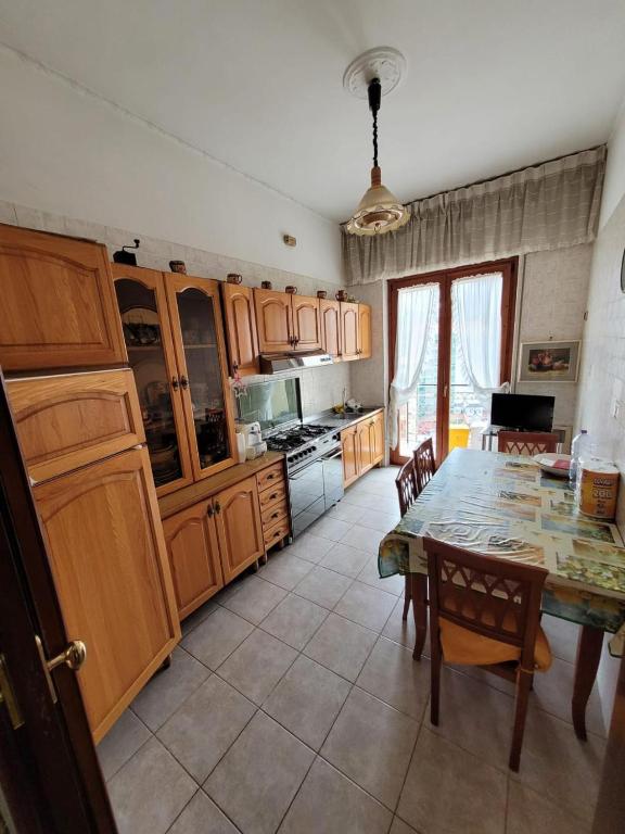 een keuken met een tafel en houten kasten bij Avellino residence centralissimo in Avellino