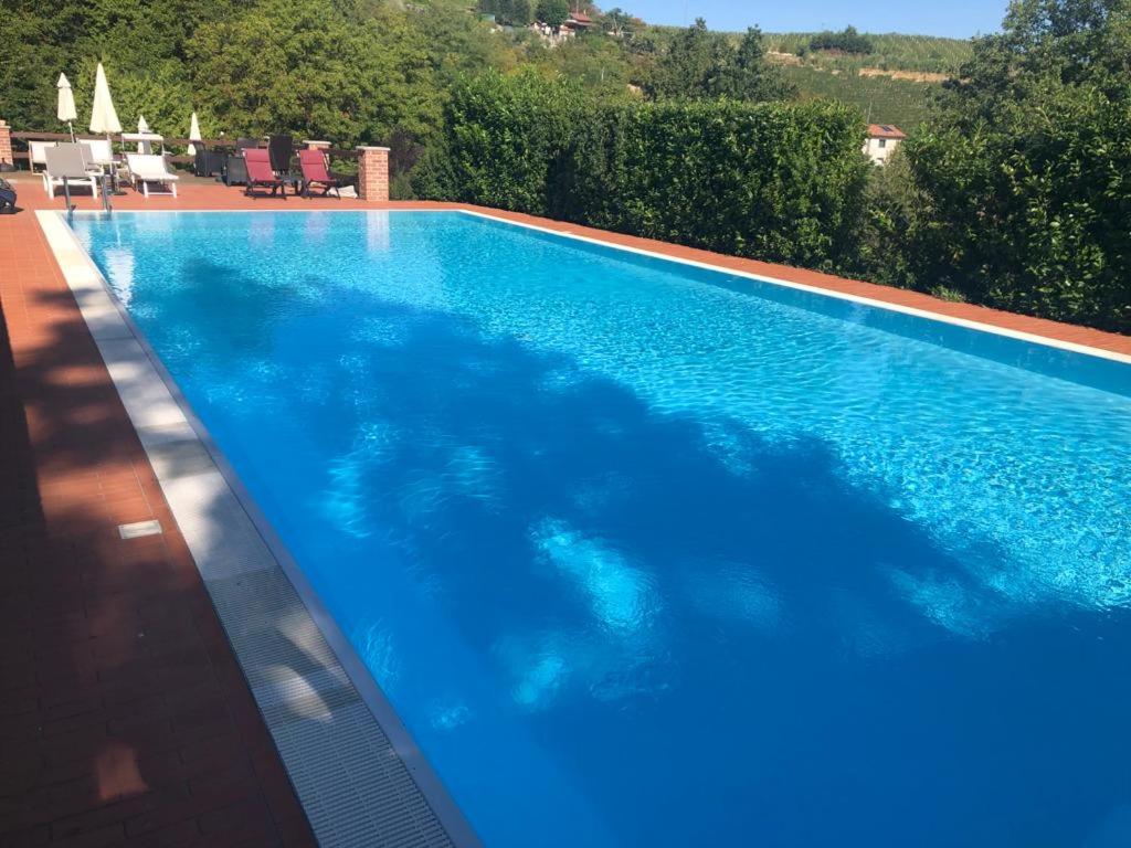 a large blue swimming pool in a yard at StarsBox CasaSilvana in Alba