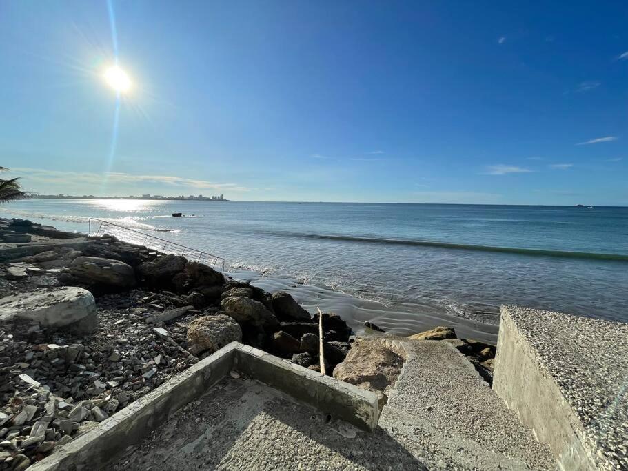 a beach with rocks and the ocean on a sunny day at Suite a pasos de la playa! in Salinas