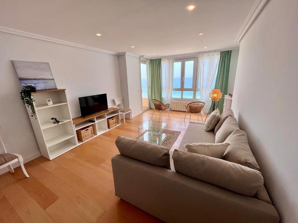 uma sala de estar com um sofá e uma televisão em GATU PREMIUM Villa Turquesa Playa y Parking em Cádiz