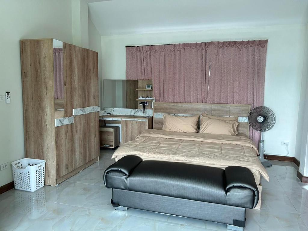 Un dormitorio con una cama grande y una cocina. en เชียงใหม่ บ้านสันติสุข, en Ban Ku Sua