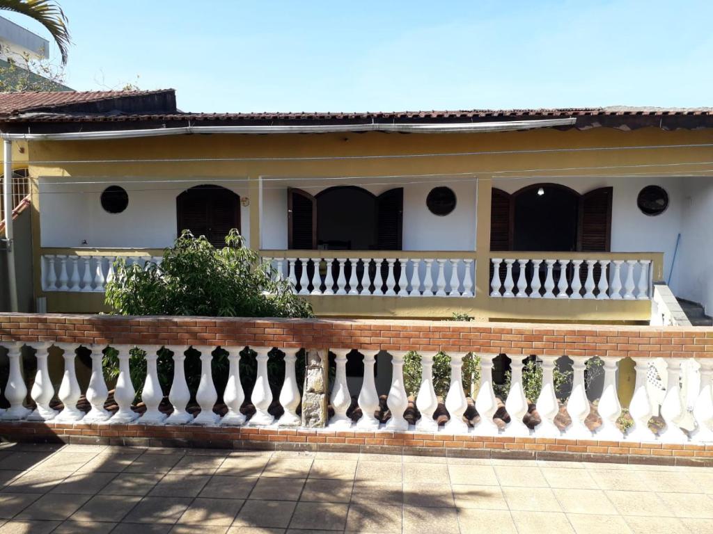 una casa con una cerca blanca delante de ella en Hostel Canto de Bertioga en Bertioga