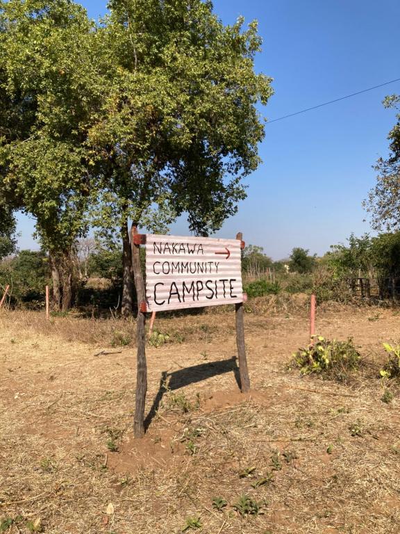 a sign sitting in the middle of a field at Nakawa Community Campsite in Kazungula