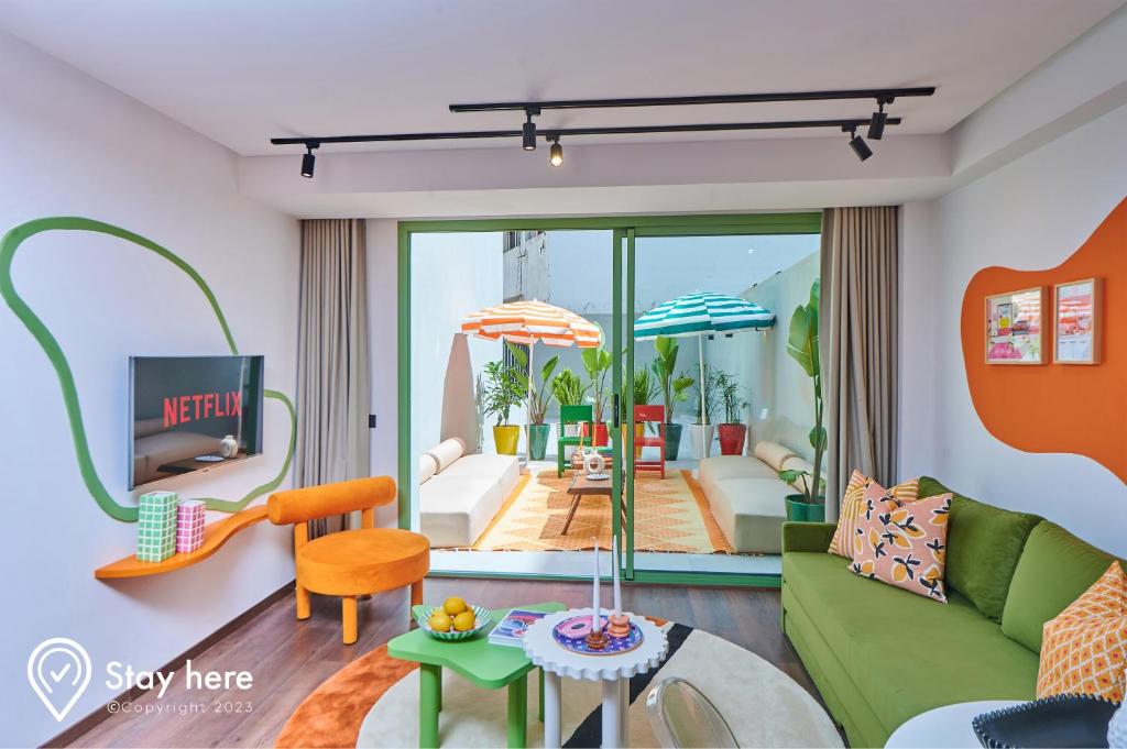 Stayhere Casablanca - CIL - Vibrant Residence في الدار البيضاء: غرفة معيشة مع أريكة خضراء وطاولة