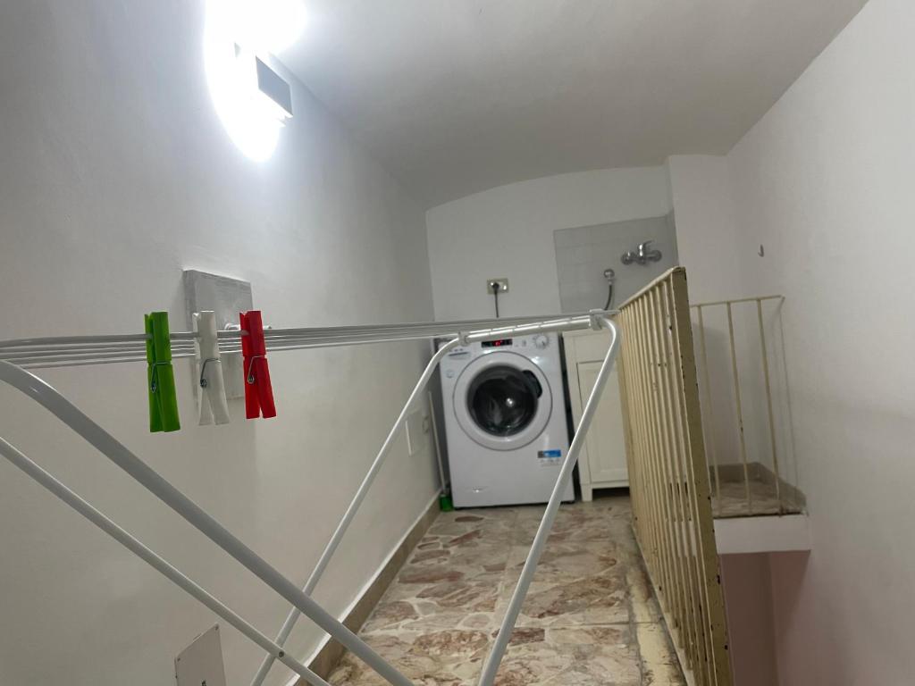 uma lavandaria com uma máquina de lavar roupa num quarto em A piscaria em Catânia