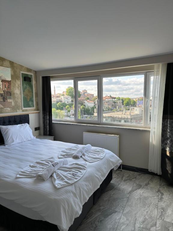 a bedroom with a bed and a large window at Mar Boutique Apartment in Istanbul