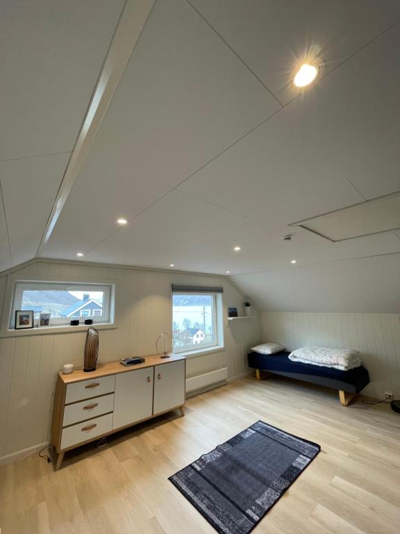 Zimmer im Dachgeschoss mit einem Bett und einem Schreibtisch in der Unterkunft Fjordgård Mountain Aurora View in Fjordgård