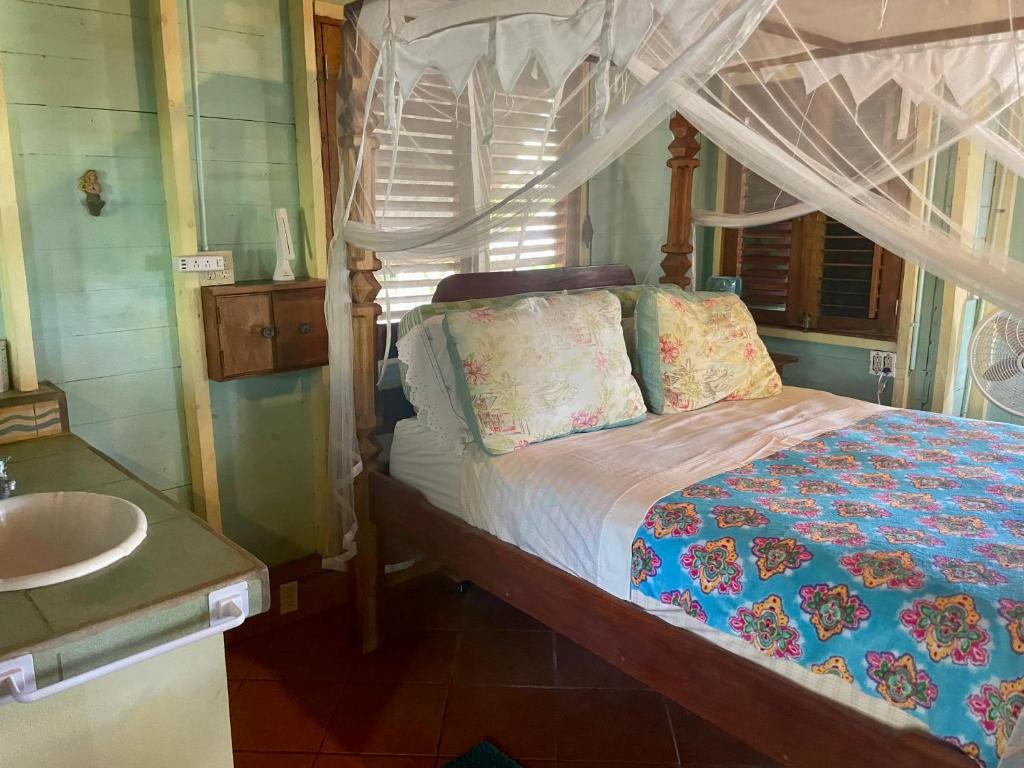 Schlafzimmer mit einem Bett, einem Waschbecken und einem Waschbecken in der Unterkunft Treehouse Apartment at La Lodge at Long Bay in Corn Island