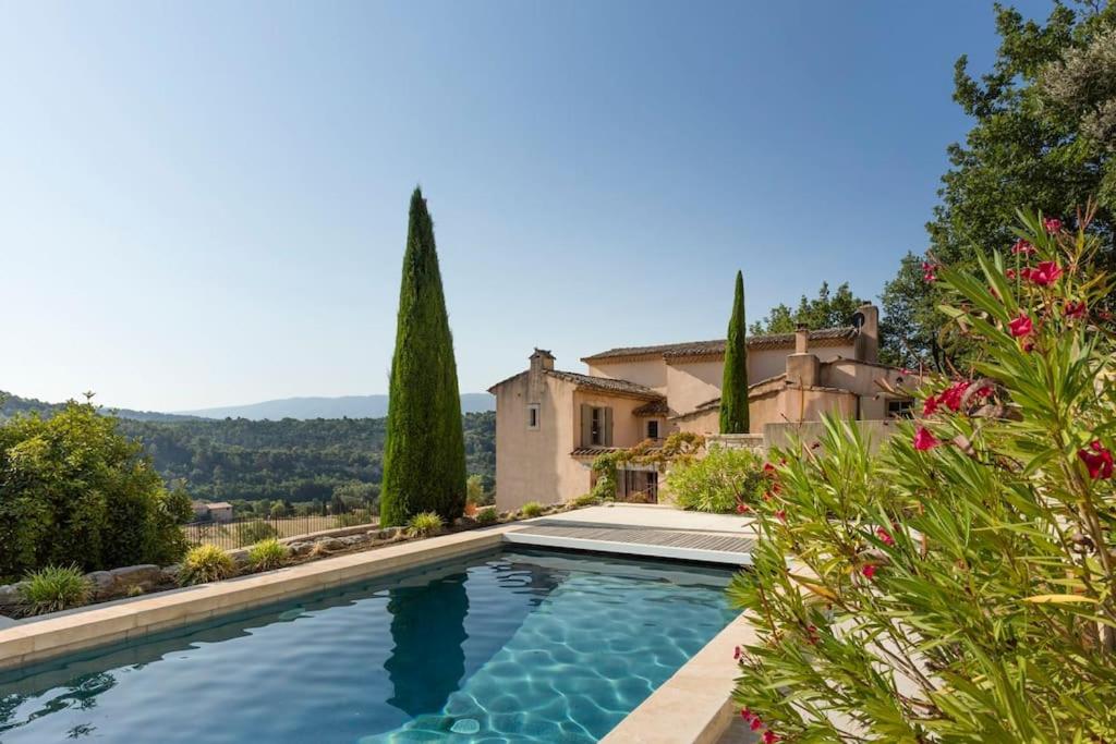 a swimming pool in front of a house at Bastide la Belle Étoile in Apt