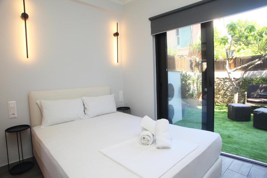 a bedroom with a white bed and a large window at InTown Suite in Lefkada Town